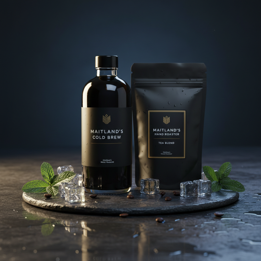 Maitland's Hand Roaster Cold Brew & Tea bottle on dark wet stone with ice and mint