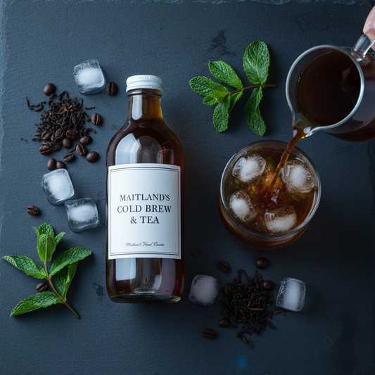 Maitland's Hand Roaster Cold Brew & Tea flat lay on dark slate with ice, coffee beans and tea leaves